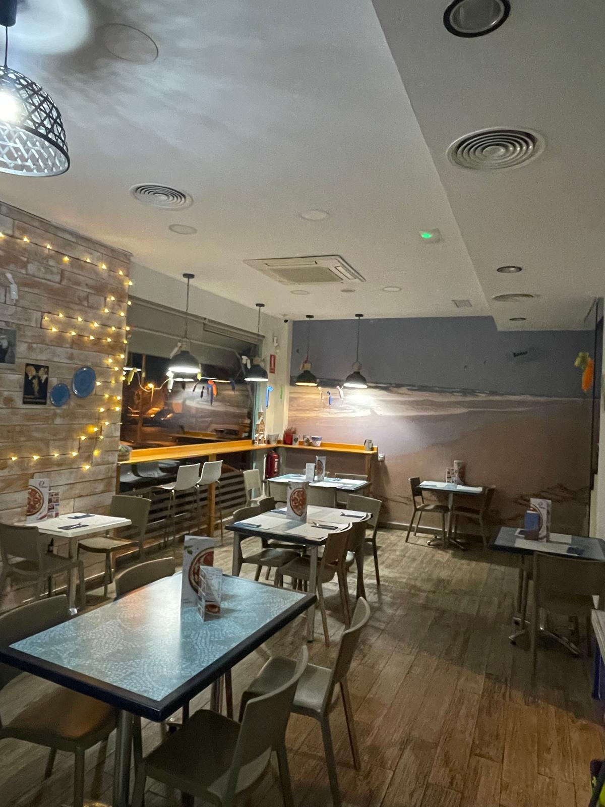 Interior del restaurante - Ambiente acogedor con mesas y decoración moderna